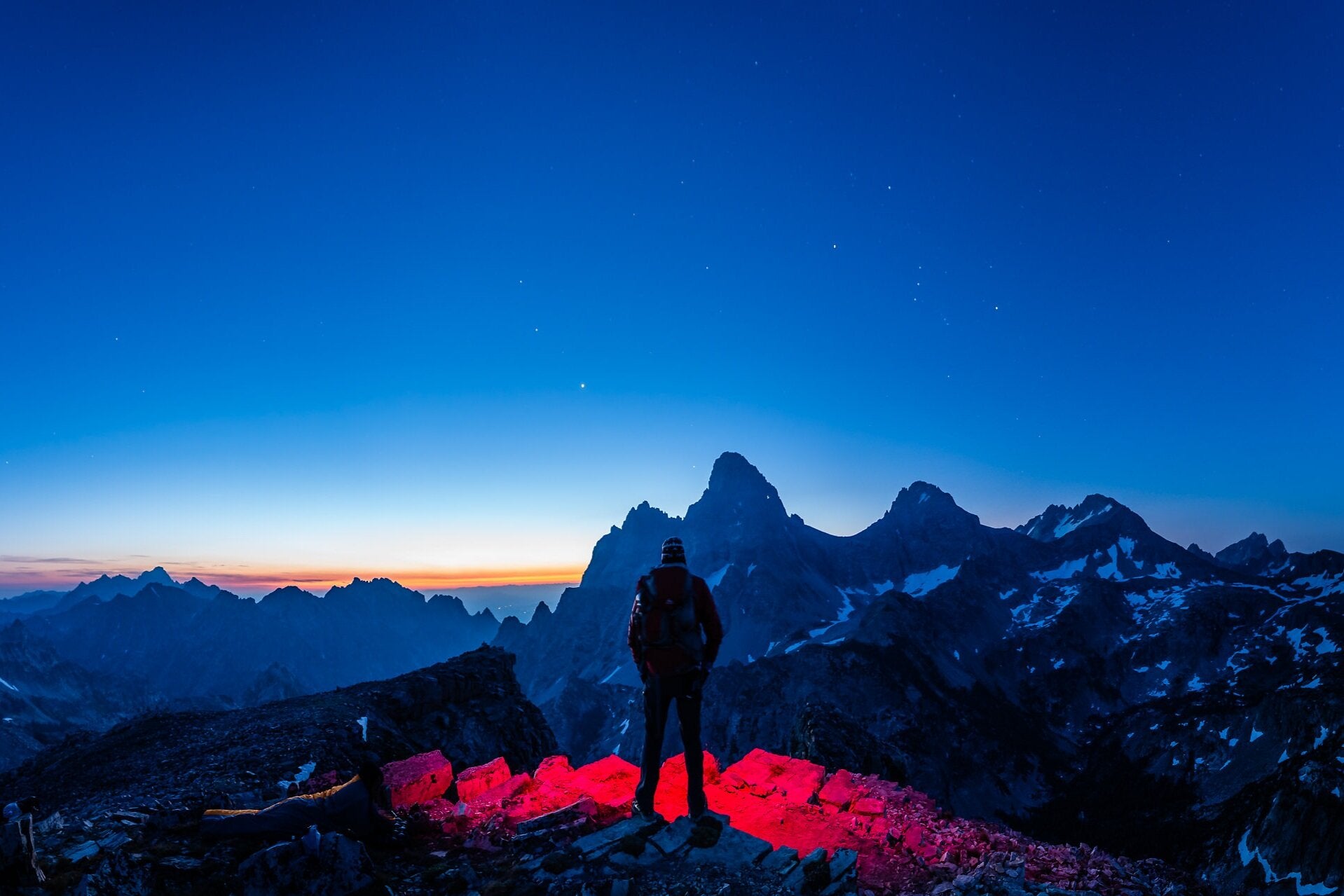 Sean Hoyt and his red headlamp await the arrival of sunrise at Grand Teton National Park.